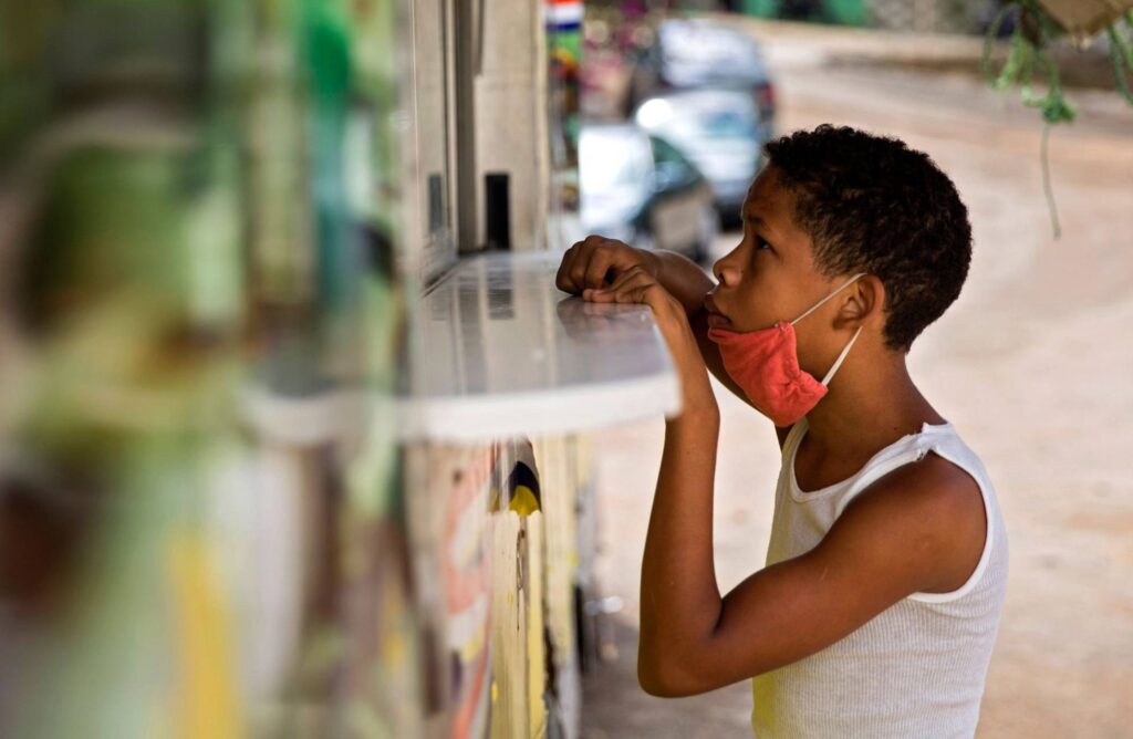 Gráfica: Un niño espera a recibir una comida gratis en un camión de comidas del Gobierno en Santo Domingo (República Dominicana). ERIKA SANTELICES AFP
