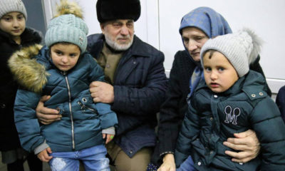 Dos menores rusos son recibidos el pasado febrero por unos familiares en el aeropuerto de Grozni (Chechenia). YELENA AFONINA (GETTY)