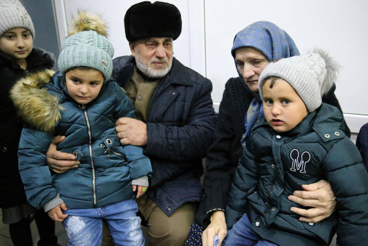 Dos menores rusos son recibidos el pasado febrero por unos familiares en el aeropuerto de Grozni (Chechenia). YELENA AFONINA (GETTY)